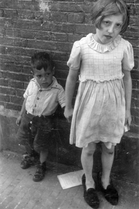 221141 Afbeelding van een jongen en een meisje in, (waarschijnlijk) de Oranjehof te Utrecht.N.B. Op de achterzijde is, ...